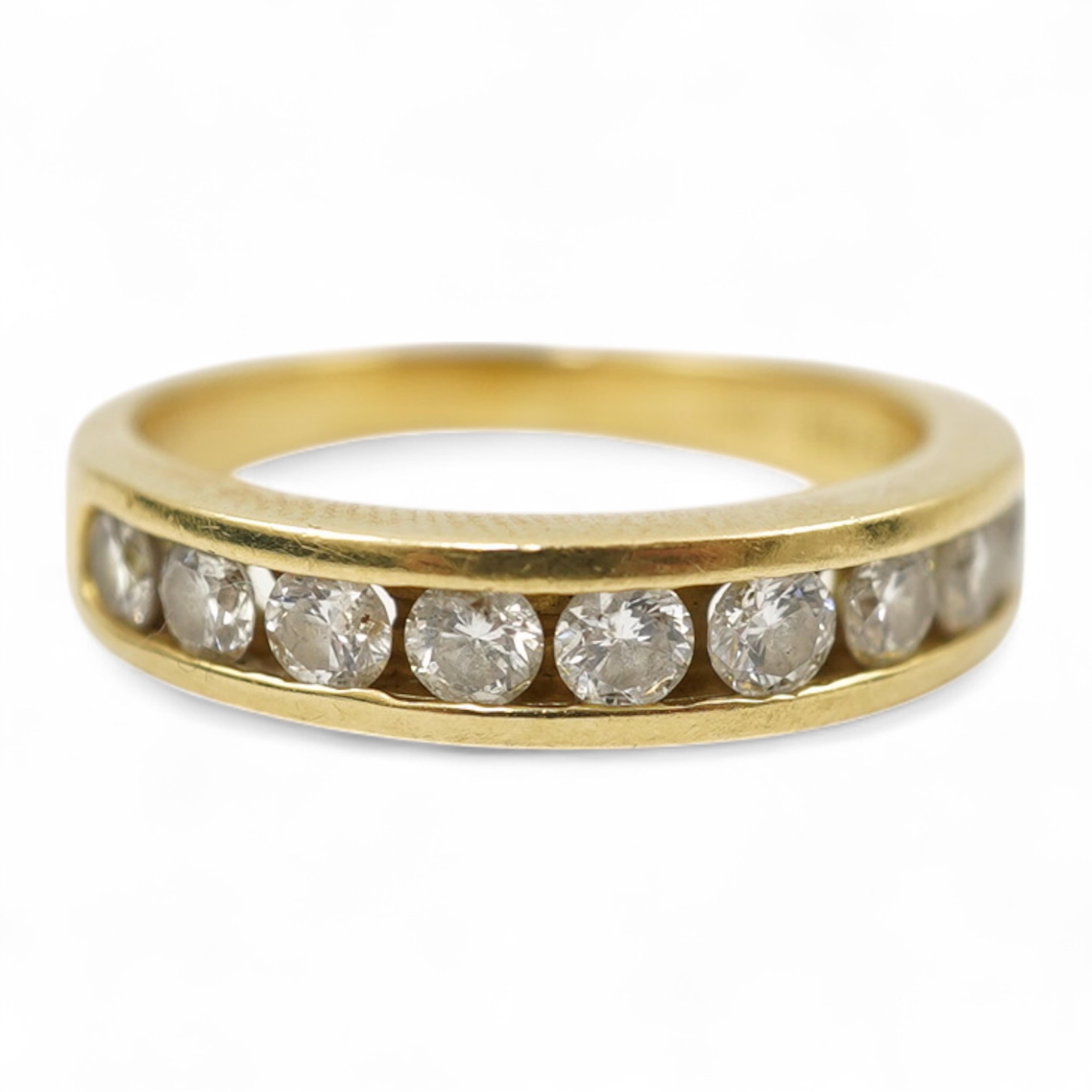 A modern 18ct gold and channel set graduated ten stone diamond set half eternity ring, size Q, gross weight 5.4 grams.